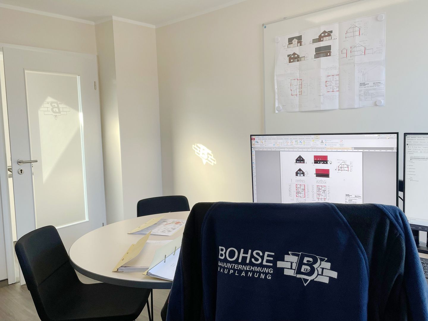 Ein Schreibtisch mit einem Computer und einem Laptop darauf, der eine moderne Arbeitsumgebung darstellt.